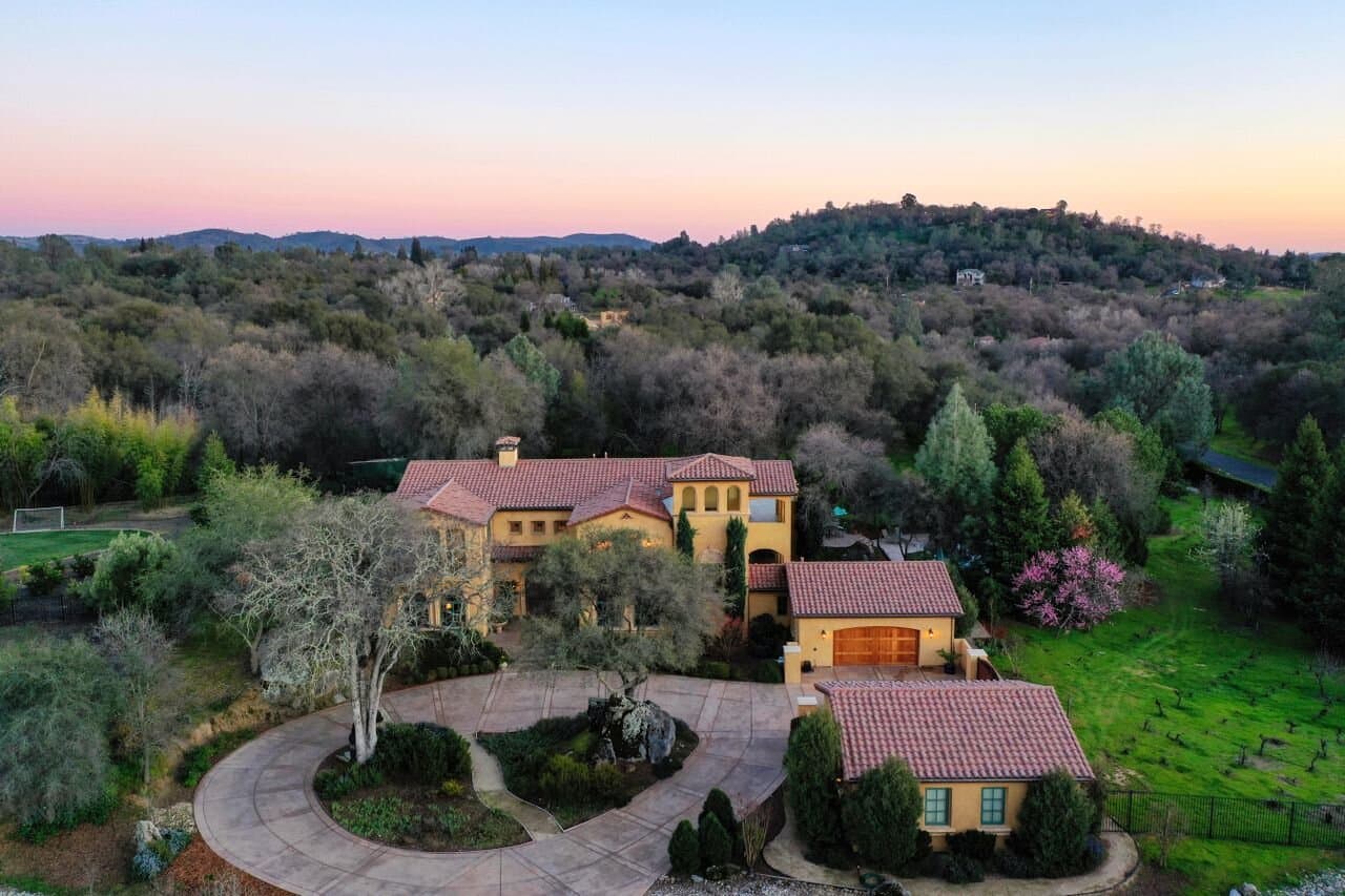 Estate home with a tile roof set against canyon hillsides